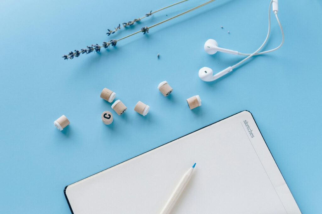 A minimalist flat lay composition of desk essentials on a blue background, ideal for business and design themes.