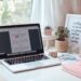 Staying professional with Grammarly Minimalist home office setup with a pink keyboard and a laptop, representing professional freelance writing and editing